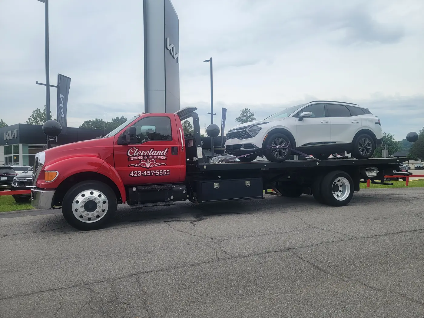 An SUV loaded on the rollback at a dealership