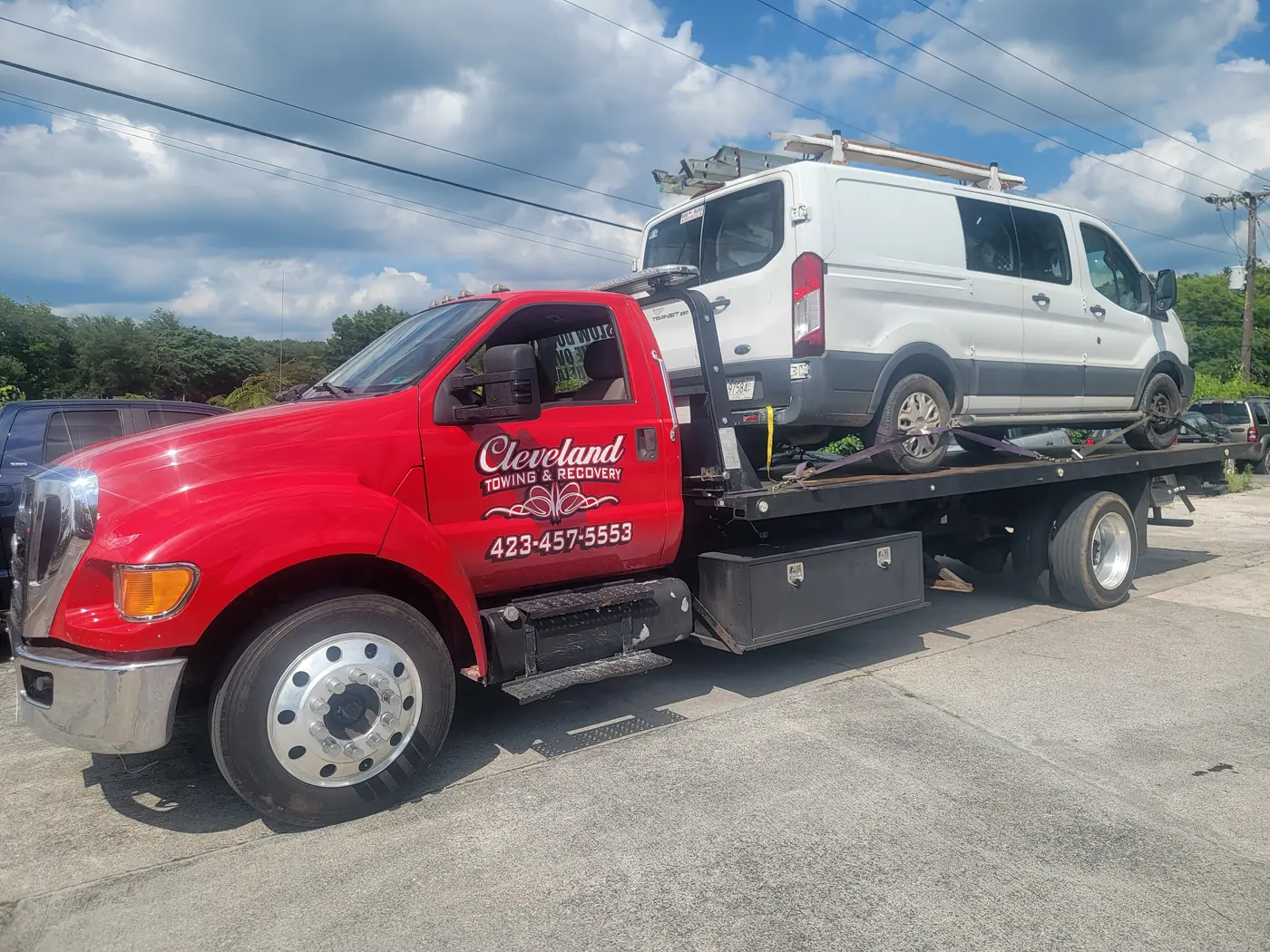 A commercial cargo van with a roof ladder rack on the deck