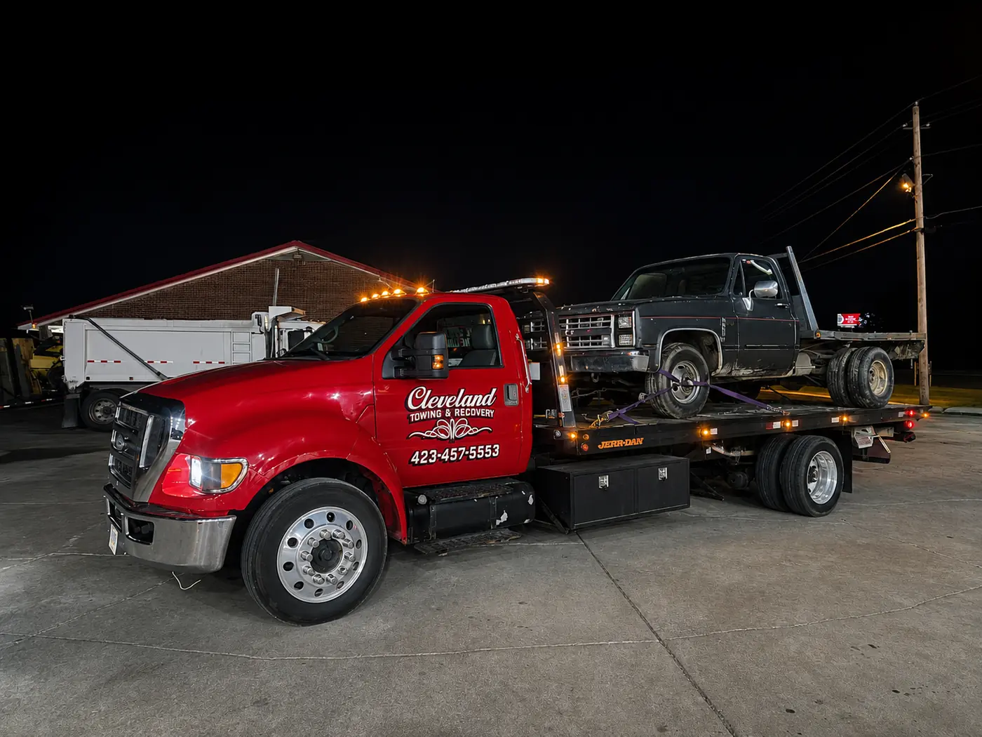 An older non-running pickup loaded on the deck at night