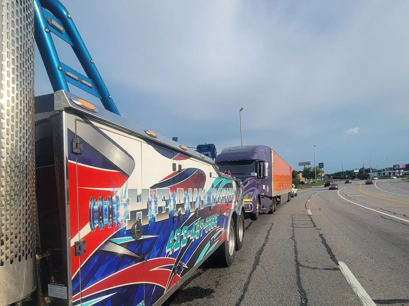The boom of our heavy wrecker rigged to a tractor-trailer stopped on the shoulder of a highway